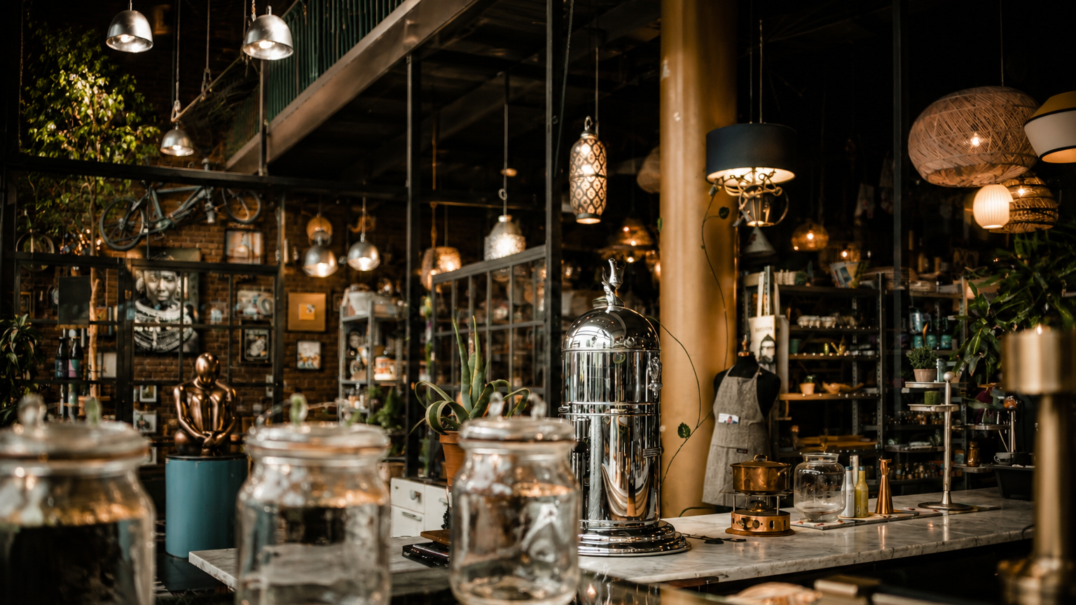 Elegantes Café mit stilvollen Lampen, Pflanzen und Gläsern auf einem Holztisch.