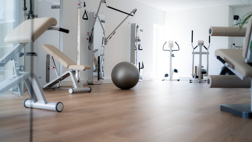 Moderne Fitnessstudio mit verschiedenen Trainingsgeräten und einem Gymnastikball.